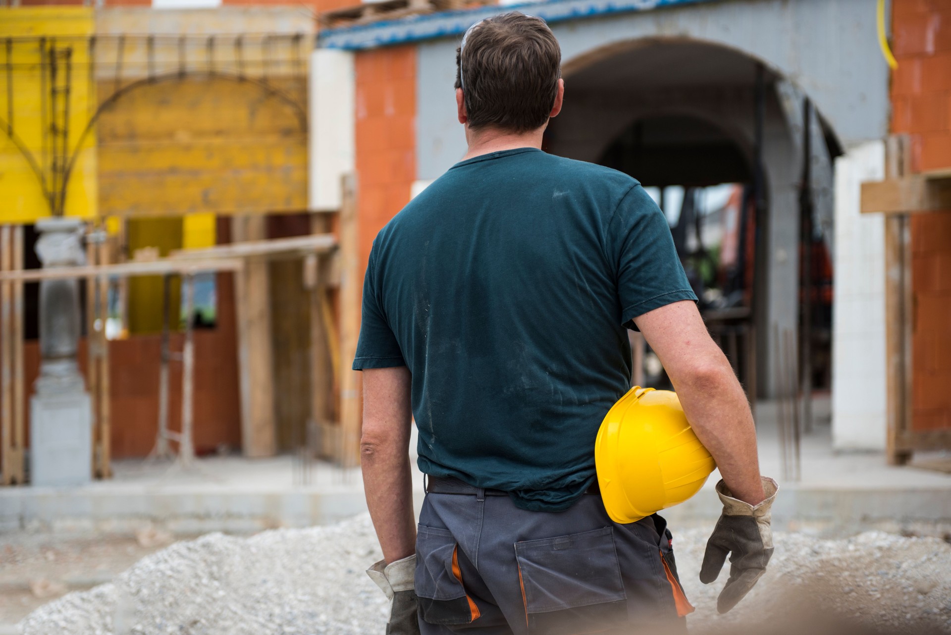 Construction worker holding yellow hemlet